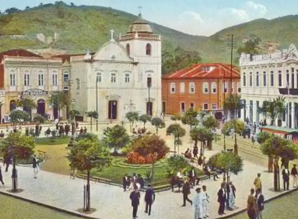 Vista panorâmica colorizada do Largo do Rosário em Santos, mostrando a praça arborizada, a arquitetura colonial da igreja e o movimento de pessoas e bondes no centro histórico.